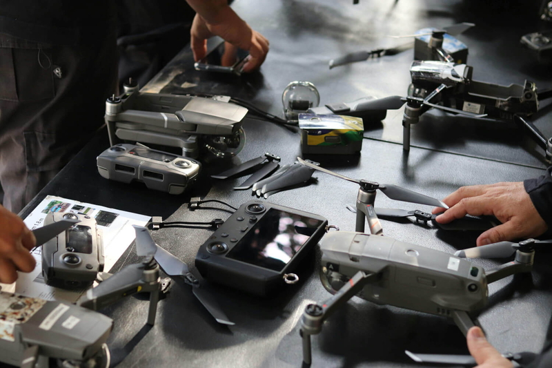 Technician repairing and optimizing flying drones and cameras to enhance productivity and performance.